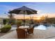 Backyard oasis featuring a pool, patio seating, mature landscaping, and a sunset view at 11617 E Raintree Dr, Scottsdale, AZ 85255