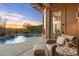 Covered patio with a view of the pool, mature landscape, and a view of the sunset at 11617 E Raintree Dr, Scottsdale, AZ 85255