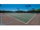 Well-maintained tennis court with professional lighting for evening play, surrounded by lush greenery at 11617 E Raintree Dr, Scottsdale, AZ 85255