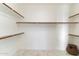 Clean, bright walk-in closet offers ample shelving and storage space with marbled floors at 11617 E Raintree Dr, Scottsdale, AZ 85255