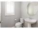 Powder room with pedestal sink, oval mirror, and neutral paint at 1170 E Taylor Trl, San Tan Valley, AZ 85143