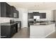 A kitchen featuring dark cabinets, stainless steel appliances, and a large island with a granite countertop at 1170 E Taylor Trl, San Tan Valley, AZ 85143