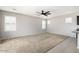 A spacious living room featuring carpet flooring, a ceiling fan, and natural light from windows with plantation shutters at 1170 E Taylor Trl, San Tan Valley, AZ 85143