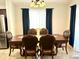 Elegant dining area featuring a wooden table with decorative chairs and dark blue curtains at 12008 W Acapulco Dr, El Mirage, AZ 85335
