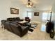 Spacious living room boasts vaulted ceilings, tile floors, and comfortable leather seating at 12008 W Acapulco Dr, El Mirage, AZ 85335