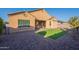 Desert landscaped backyard with a small patch of artificial grass at 15993 W Poinsettia Dr, Surprise, AZ 85379