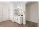 Bright bathroom with wood floors, a sleek white vanity, and large mirror at 15993 W Poinsettia Dr, Surprise, AZ 85379