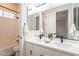 Bright bathroom with a double sink vanity, quartz countertops, matte black hardware and a shower/tub combo at 15993 W Poinsettia Dr, Surprise, AZ 85379