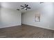 Neutral bedroom with sleek ceiling fan, wood floors, and sunlit window at 15993 W Poinsettia Dr, Surprise, AZ 85379