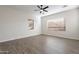 Bright and airy bedroom featuring wood flooring, a modern fan, and multiple sunlit windows at 15993 W Poinsettia Dr, Surprise, AZ 85379