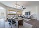 Dining area with modern chandelier lighting over a wooden table and black chairs at 15993 W Poinsettia Dr, Surprise, AZ 85379