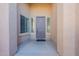 Covered porch featuring a welcoming front door flanked by sidelight windows for natural light at 15993 W Poinsettia Dr, Surprise, AZ 85379