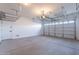 Spacious garage with an automatic door, overhead storage racks and a door to the home interior at 15993 W Poinsettia Dr, Surprise, AZ 85379