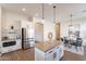 Open concept kitchen and dining area with stainless steel refrigerator and island at 15993 W Poinsettia Dr, Surprise, AZ 85379