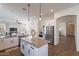 Open kitchen with large island, pendant lighting, and stainless steel refrigerator at 15993 W Poinsettia Dr, Surprise, AZ 85379