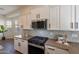 Modern kitchen features stainless appliances, white cabinetry and hexagon tile backsplash at 15993 W Poinsettia Dr, Surprise, AZ 85379