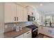 Modern kitchen features stainless appliances, white cabinetry and hexagon tile backsplash at 15993 W Poinsettia Dr, Surprise, AZ 85379