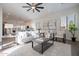 Open-concept living room with kitchen view, modern decor, and bright natural light at 15993 W Poinsettia Dr, Surprise, AZ 85379