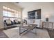 Bright living room featuring stylish seating, modern decor, and a large window at 15993 W Poinsettia Dr, Surprise, AZ 85379
