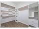 This walk-in closet features built-in shelving, drawers and a hanging rod for optimal storage at 15993 W Poinsettia Dr, Surprise, AZ 85379
