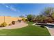 Expansive backyard featuring a built-in grill, verdant artificial grass, and a luxurious pool with rock waterfall feature at 1633 N Woodruff --, Mesa, AZ 85207