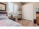 Cozy bedroom featuring plantation shutters, hardwood floors, a full size bed and mirrored wall art at 1633 N Woodruff --, Mesa, AZ 85207