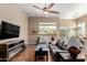A comfortable living room featuring a large window, tile flooring, and a cozy leather sofa at 1633 N Woodruff --, Mesa, AZ 85207