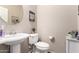 Well-lit powder room featuring a pedestal sink and charming decor at 17474 W Straight Arrow Ln, Surprise, AZ 85387