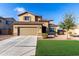 Two-story home featuring a neutral stucco facade, two-car garage, and well-manicured front lawn at 17474 W Straight Arrow Ln, Surprise, AZ 85387