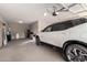 Garage featuring a light colored car, storage and clean flooring at 17474 W Straight Arrow Ln, Surprise, AZ 85387