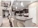 Well-equipped kitchen with island, bar seating, dark wood cabinets, stainless steel appliances, and pendant lighting at 17474 W Straight Arrow Ln, Surprise, AZ 85387