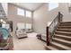 Bright living room with soaring ceilings, large windows, plush seating, and staircase at 17474 W Straight Arrow Ln, Surprise, AZ 85387
