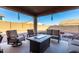 Covered patio with comfortable seating and a modern fire pit table at 17474 W Straight Arrow Ln, Surprise, AZ 85387