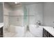 Bathroom featuring a white soaking tub, a glass enclosed shower, dark cabinets, and white countertops at 20061 E Cherrywood Ct, Queen Creek, AZ 85142