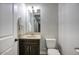 A cozy bathroom features a dark wood vanity, neutral stone countertop, and bright vanity lighting at 20061 E Cherrywood Ct, Queen Creek, AZ 85142