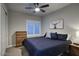 Cozy bedroom boasts a ceiling fan, wood dresser, and natural light at 20061 E Cherrywood Ct, Queen Creek, AZ 85142