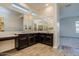 Beautiful bathroom with a large mirror, dual sinks, and wood look floors and vanity at 21255 W Ashland Ave, Buckeye, AZ 85396