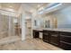 Elegant bathroom with glass shower enclosure, dual sinks, and a spacious walk-in closet at 21255 W Ashland Ave, Buckeye, AZ 85396