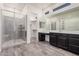 This bathroom features dual sinks, walk in closet, glass enclosed shower and wood look tile at 21255 W Ashland Ave, Buckeye, AZ 85396