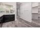 This bathroom features dual sinks, a walk in closet and wood look tile at 21255 W Ashland Ave, Buckeye, AZ 85396