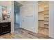 Bathroom with wood look flooring, cabinets and a closet through an open doorway at 21255 W Ashland Ave, Buckeye, AZ 85396