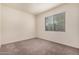 This bedroom features neutral carpeting and a window that provides plenty of natural light at 21255 W Ashland Ave, Buckeye, AZ 85396