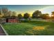 Sienna Hills Community Park featuring vibrant greenery, mature trees, and clear signage at sunset at 21255 W Ashland Ave, Buckeye, AZ 85396