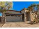 Spacious two-car garage with desert landscaping and a stone facade, complemented by a well-lit entryway at 21255 W Ashland Ave, Buckeye, AZ 85396