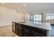 Kitchen island features a stainless steel dishwasher, a sink, and a modern faucet with ample countertop at 21255 W Ashland Ave, Buckeye, AZ 85396