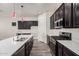 Well-equipped kitchen with stainless steel appliances, a center island, dark wood cabinets, and stylish pendant lighting at 21255 W Ashland Ave, Buckeye, AZ 85396