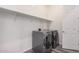 Bright laundry room with washer and dryer hookups and overhead shelving at 21255 W Ashland Ave, Buckeye, AZ 85396