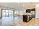 Open living area with sliding glass doors to the backyard and a kitchen island with a sink at 21255 W Ashland Ave, Buckeye, AZ 85396