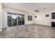 Bright living room with wood-look tile flooring, a ceiling fan, and sliding glass doors leading to the backyard at 21255 W Ashland Ave, Buckeye, AZ 85396