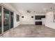 Open-concept living room featuring sleek tile flooring, a ceiling fan, and access to the kitchen and backyard at 21255 W Ashland Ave, Buckeye, AZ 85396